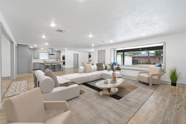10011 Cliffwood Dr, Houston, TX 77035 - living room featuring recessed lighting, light wood-type flooring, and a textured ceiling