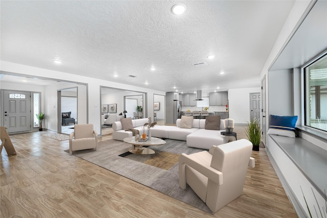 10011 Cliffwood Dr, Houston, TX 77035 - living room featuring a textured ceiling, light wood-style floors, and recessed lighting