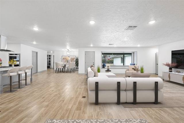 10011 Cliffwood Dr, Houston, TX 77035 - living room featuring light wood-type flooring, recessed lighting, and a textured ceiling
