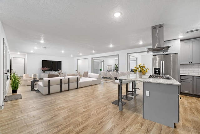 10011 Cliffwood Dr, Houston, TX 77035 - kitchen featuring stainless steel appliances, gray cabinets, open floor plan, light wood finished floors, and a textured ceiling