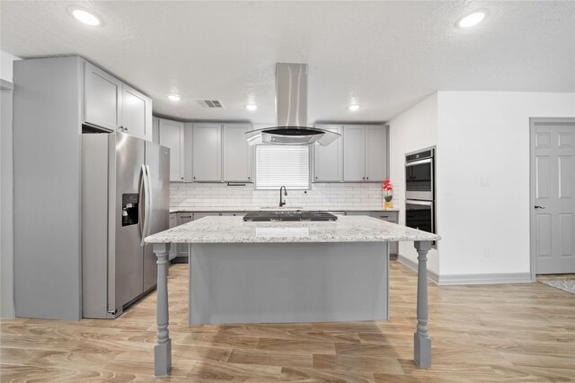 10011 Cliffwood Dr, Houston, TX 77035 - kitchen with appliances with stainless steel finishes, island range hood, tasteful backsplash, a kitchen island, and light stone counters