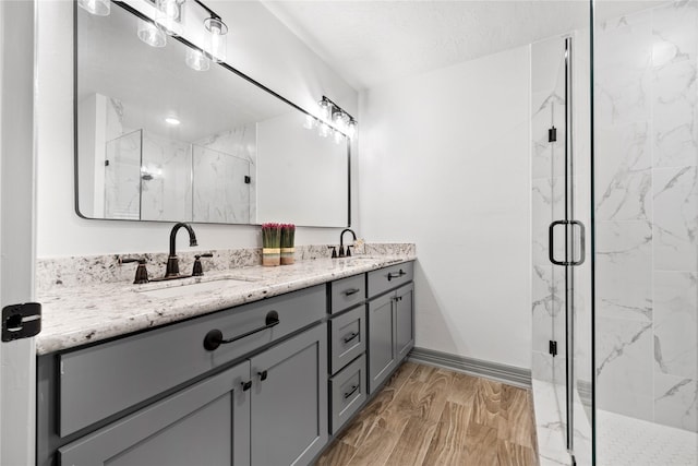10011 Cliffwood Dr, Houston, TX 77035 - bathroom with double vanity, a marble finish shower, and wood finished floors