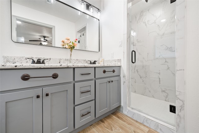10011 Cliffwood Dr, Houston, TX 77035 - bathroom featuring a marble finish shower, double vanity, a ceiling fan, and wood finished floors