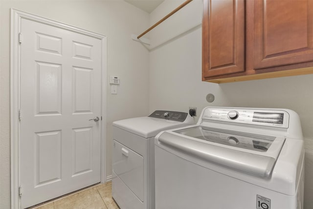 12106 Coldwater Cove Ln, Cypress, TX 77433 - washroom with cabinet space, washing machine and dryer, and light tile patterned floors