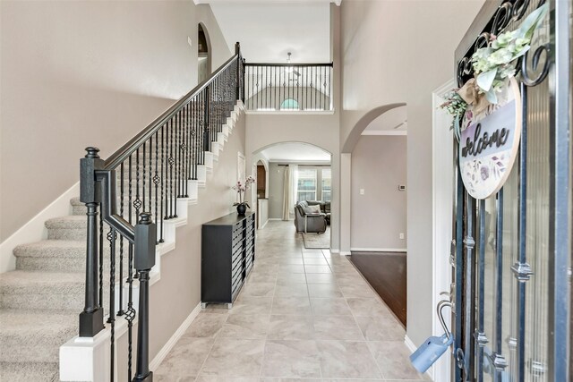 12106 Coldwater Cove Ln, Cypress, TX 77433 - entryway with arched walkways, a towering ceiling, stairway, and light tile patterned floors