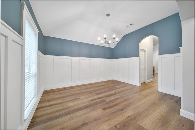 28006 Brendon Trail Ct, Spring, TX 77386 - unfurnished room featuring arched walkways, wood finished floors, a decorative wall, lofted ceiling, and wainscoting