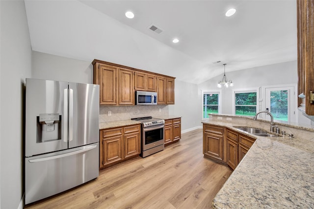 28006 Brendon Trail Ct, Spring, TX 77386 - kitchen with stainless steel appliances, lofted ceiling, brown cabinets, light wood-type flooring, and recessed lighting