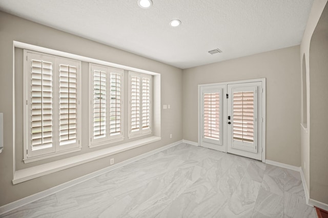 22419 Rippling Shore Ct, Katy, TX 77494 - unfurnished room featuring marble look tile flooring, a textured ceiling, and recessed lighting