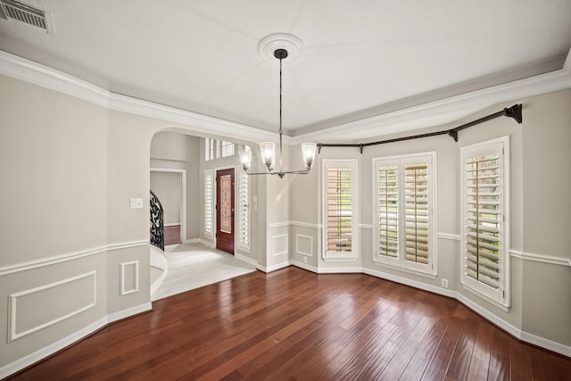 22419 Rippling Shore Ct, Katy, TX 77494 - unfurnished dining area with a chandelier, wood-type flooring, arched walkways, and crown molding