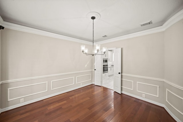 22419 Rippling Shore Ct, Katy, TX 77494 - unfurnished dining area featuring a chandelier, dark wood-style floors, ornamental molding, wainscoting, and a decorative wall