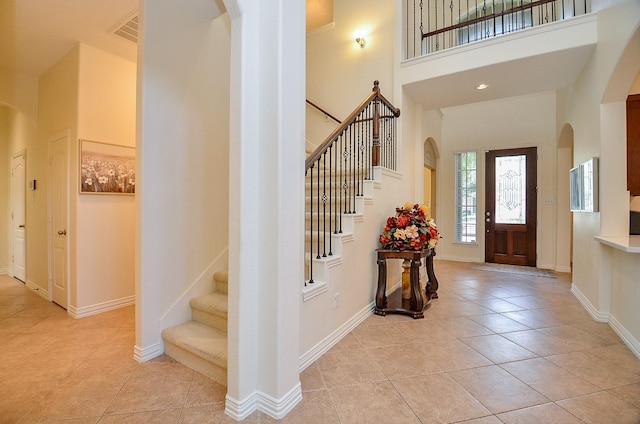 24914 Hazel Ranch Dr, Katy, TX 77494 - foyer with light tile patterned flooring, arched walkways, stairs, and a towering ceiling