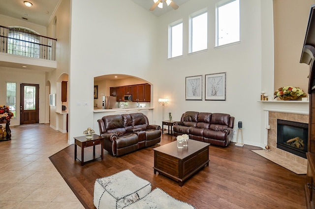 24914 Hazel Ranch Dr, Katy, TX 77494 - living area with a towering ceiling, plenty of natural light, a ceiling fan, and a tiled fireplace