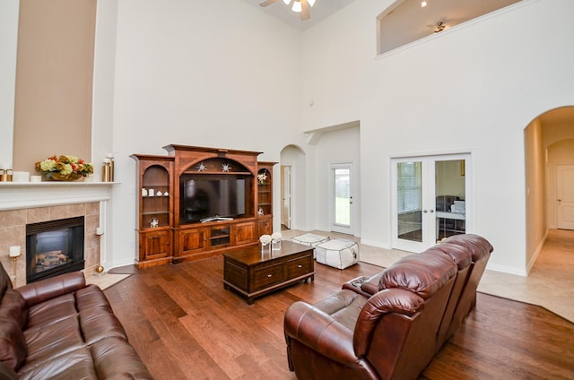 24914 Hazel Ranch Dr, Katy, TX 77494 - living area with arched walkways, ceiling fan, a towering ceiling, a fireplace, and wood finished floors