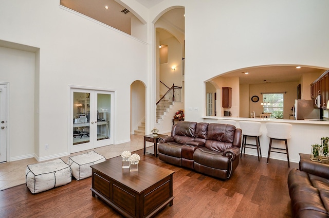 24914 Hazel Ranch Dr, Katy, TX 77494 - living room with a towering ceiling, stairs, wood finished floors, and arched walkways