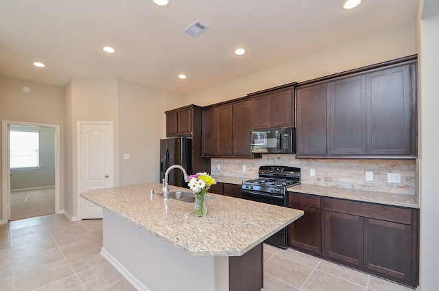 3238 Montclair Orchard Trce, Spring, TX 77386 - kitchen with black appliances, light tile patterned flooring, a center island with sink, dark brown cabinetry, and recessed lighting