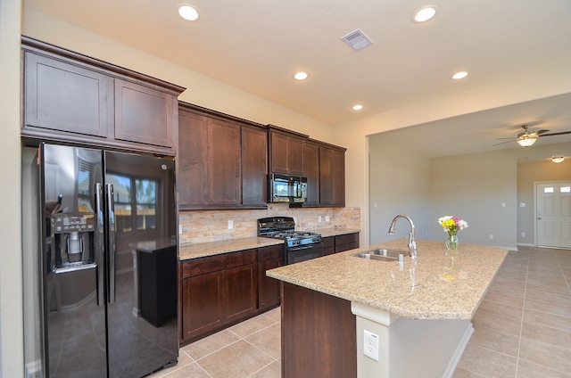 3238 Montclair Orchard Trce, Spring, TX 77386 - kitchen with black appliances, light tile patterned floors, dark brown cabinets, light stone countertops, and decorative backsplash