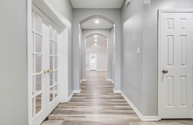 22718 Red Pine Dr, Tomball, TX 77375 - hallway featuring arched walkways, french doors, and wood finished floors