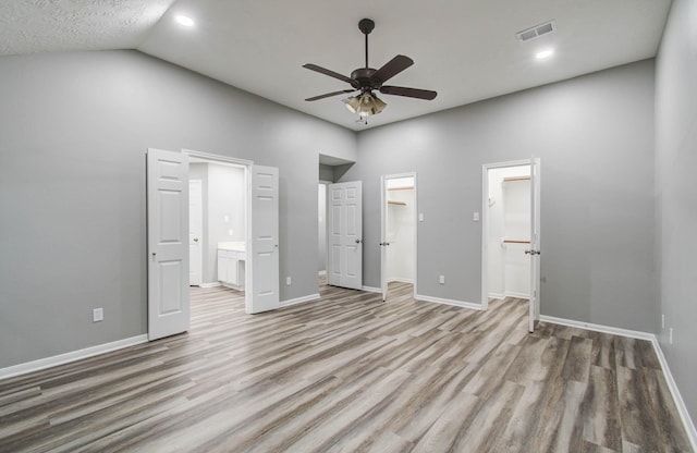 22718 Red Pine Dr, Tomball, TX 77375 - unfurnished bedroom with a spacious closet, wood finished floors, ensuite bath, vaulted ceiling, and recessed lighting