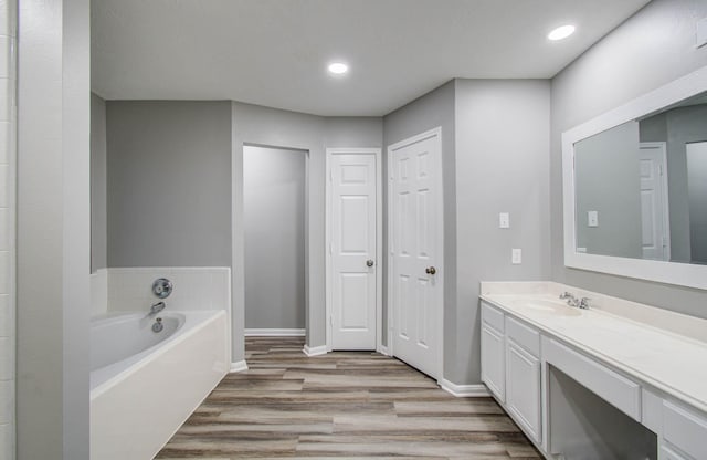 22718 Red Pine Dr, Tomball, TX 77375 - full bath featuring vanity, wood finished floors, a garden tub, and recessed lighting