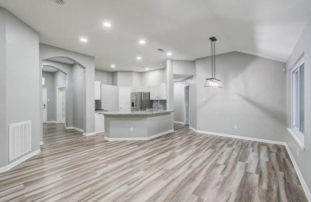 22718 Red Pine Dr, Tomball, TX 77375 - kitchen featuring stainless steel fridge, white cabinets, light wood finished floors, open floor plan, and light stone countertops