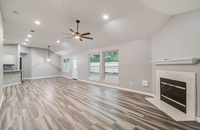 22718 Red Pine Dr, Tomball, TX 77375 - unfurnished living room with vaulted ceiling, a ceiling fan, light wood-style flooring, a fireplace, and recessed lighting