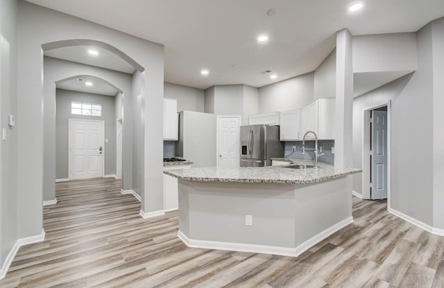22718 Red Pine Dr, Tomball, TX 77375 - kitchen featuring stainless steel fridge with ice dispenser, light wood-type flooring, light stone countertops, white cabinets, and recessed lighting