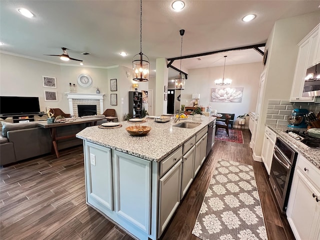 9327 Victory Canyon Ln, Tomball, TX 77375 - kitchen featuring stainless steel appliances, open floor plan, a chandelier, dark wood-style flooring, and ornamental molding