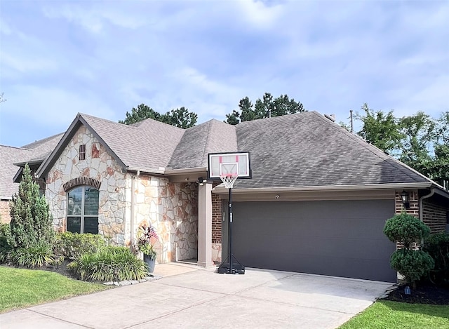 9327 Victory Canyon Ln, Tomball, TX 77375 - view of front of property with an attached garage, stone siding, concrete driveway, and a shingled roof