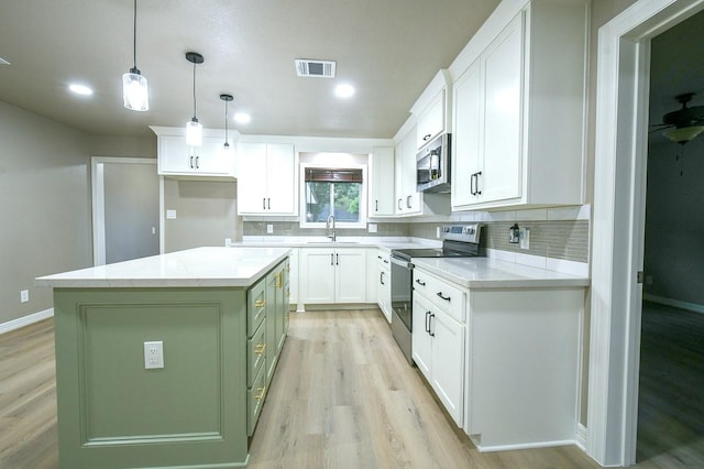 1302 W Adoue St, Alvin, TX 77511 - kitchen featuring stainless steel appliances, light wood-type flooring, white cabinets, and recessed lighting