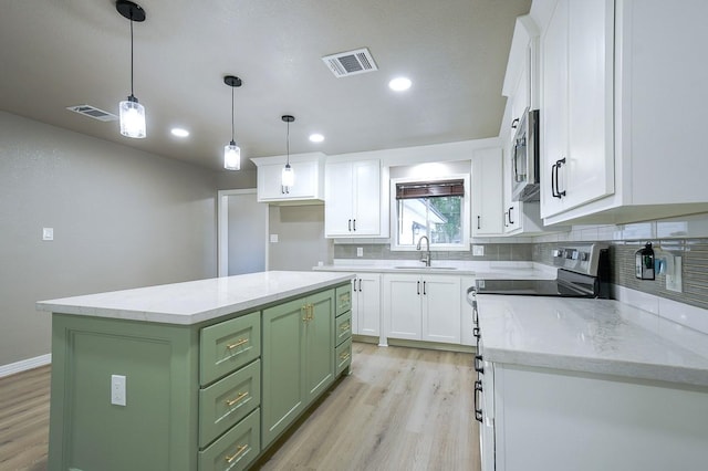 1302 W Adoue St, Alvin, TX 77511 - kitchen with green cabinets, stainless steel appliances, light wood-type flooring, white cabinetry, and recessed lighting