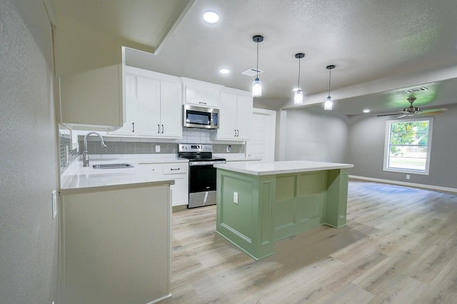 1302 W Adoue St, Alvin, TX 77511 - kitchen with stainless steel appliances, light wood-type flooring, ceiling fan, tasteful backsplash, and recessed lighting
