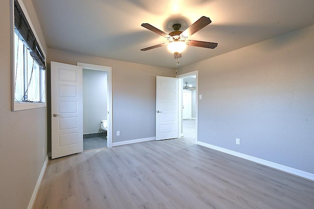1302 W Adoue St, Alvin, TX 77511 - unfurnished bedroom with wood finished floors, a ceiling fan, and connected bathroom