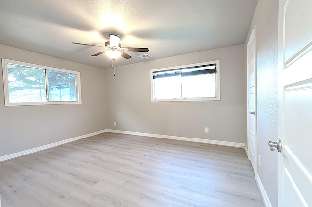 1302 W Adoue St, Alvin, TX 77511 - empty room featuring healthy amount of natural light, a ceiling fan, and light wood-style flooring