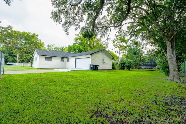 1302 W Adoue St, Alvin, TX 77511 - back of house featuring a trampoline, an attached garage, and driveway