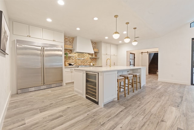 7202 Hartland Ave, Houston, TX 77055 - kitchen featuring stainless steel built in refrigerator, premium range hood, wine cooler, recessed lighting, and white cabinets