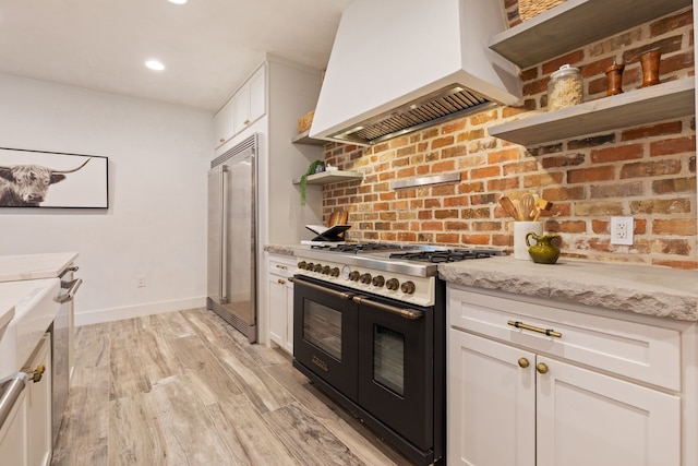 7202 Hartland Ave, Houston, TX 77055 - kitchen with open shelves, high quality appliances, premium range hood, light wood-style floors, and white cabinetry