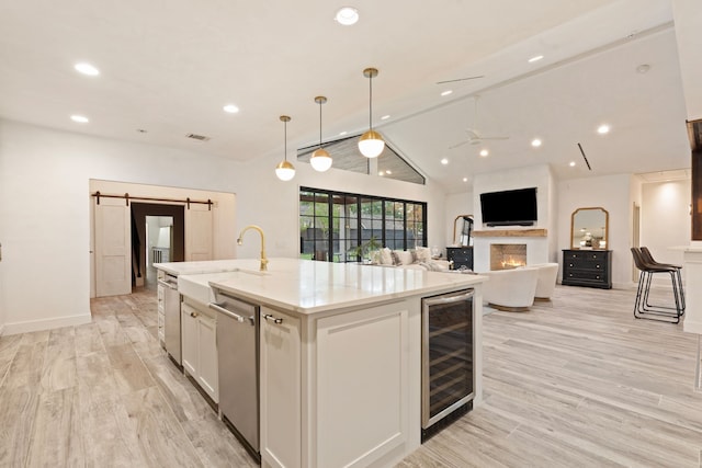 7202 Hartland Ave, Houston, TX 77055 - kitchen with wine cooler, stainless steel dishwasher, white cabinetry, a center island with sink, and lofted ceiling