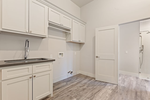 7202 Hartland Ave, Houston, TX 77055 - laundry room with washer hookup, light wood finished floors, and cabinet space