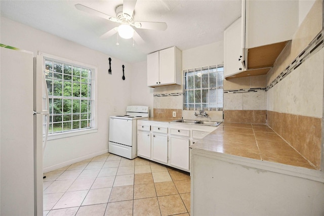 4526 Kingsbury St, Houston, TX 77021 - kitchen with white appliances, white cabinetry, ceiling fan, light tile patterned floors, and light countertops