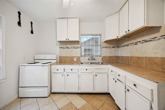 4526 Kingsbury St, Houston, TX 77021 - kitchen featuring electric stove, decorative backsplash, white cabinetry, and light tile patterned flooring