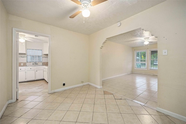 4526 Kingsbury St, Houston, TX 77021 - unfurnished room featuring a ceiling fan, light tile patterned floors, a textured ceiling, a smoke detector, and arched walkways