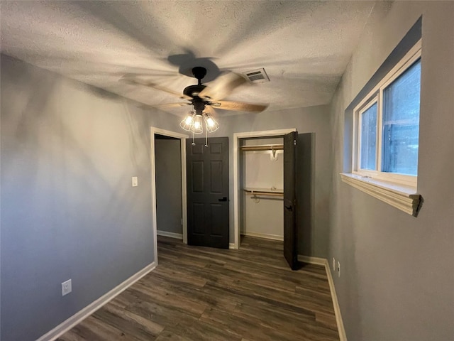126 2nd Ave, Onalaska, TX 77360 - unfurnished bedroom with a closet, a textured ceiling, dark wood-type flooring, and a ceiling fan