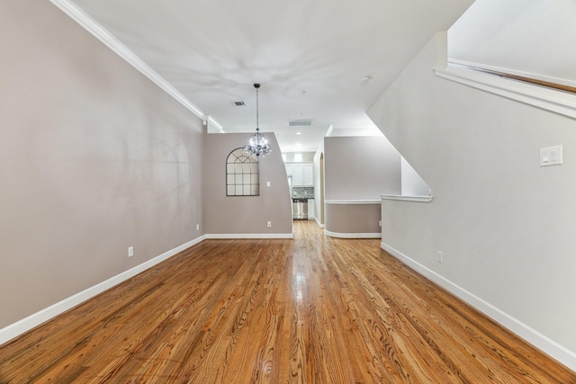 11315 S Main St Unit 1205, Houston, TX 77025 - unfurnished living room featuring wood finished floors, ornamental molding, and a chandelier