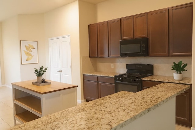 3543 Paganini Pl, Katy, TX 77493 - kitchen with black appliances, light stone counters, tasteful backsplash, and a center island