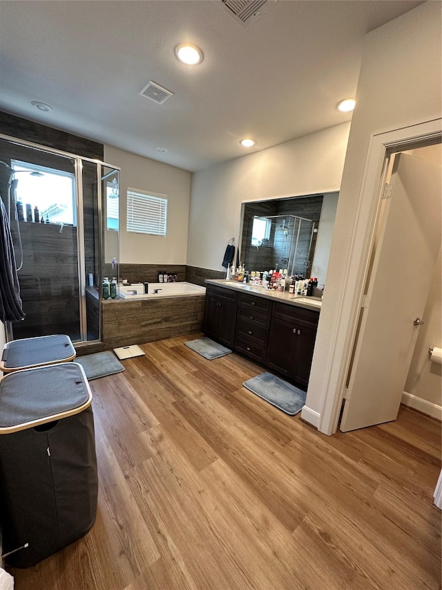 311 Eado Park Cir, Houston, TX 77020 - full bathroom featuring vanity, a garden tub, a stall shower, wood finished floors, and recessed lighting