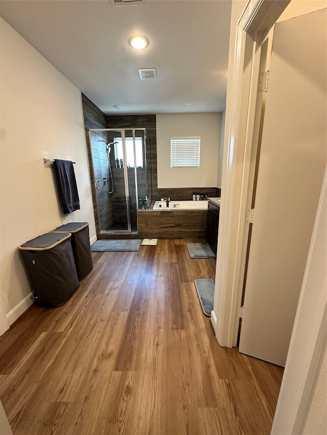 311 Eado Park Cir, Houston, TX 77020 - bathroom featuring a stall shower, a bath, and wood finished floors