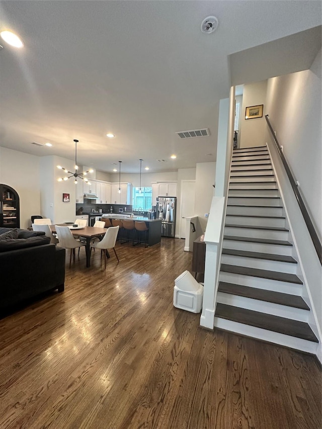 311 Eado Park Cir, Houston, TX 77020 - living room with stairway, dark wood-style floors, a chandelier, and recessed lighting