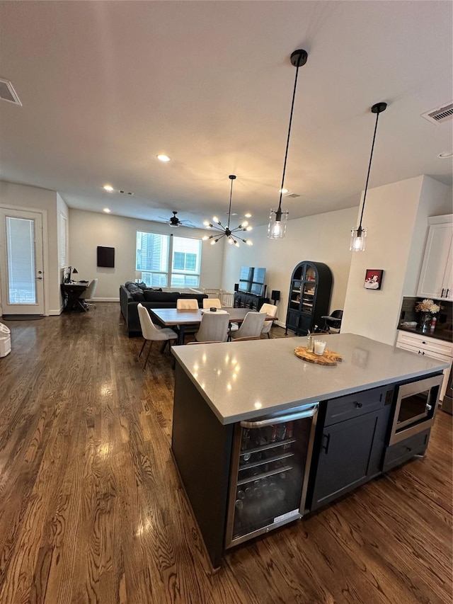 311 Eado Park Cir, Houston, TX 77020 - kitchen with wine cooler, open floor plan, stainless steel microwave, dark wood finished floors, and recessed lighting