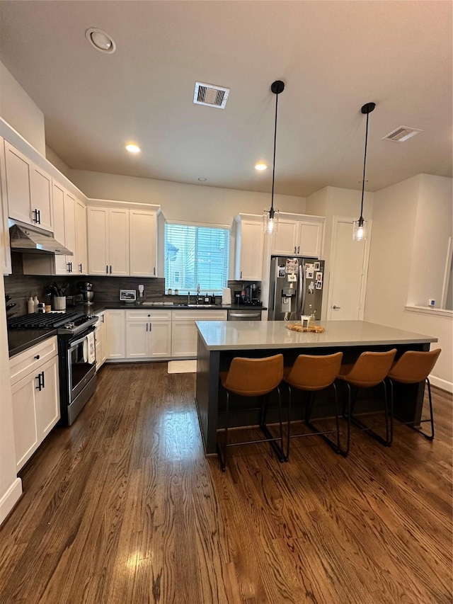 311 Eado Park Cir, Houston, TX 77020 - kitchen with appliances with stainless steel finishes, under cabinet range hood, white cabinetry, and recessed lighting