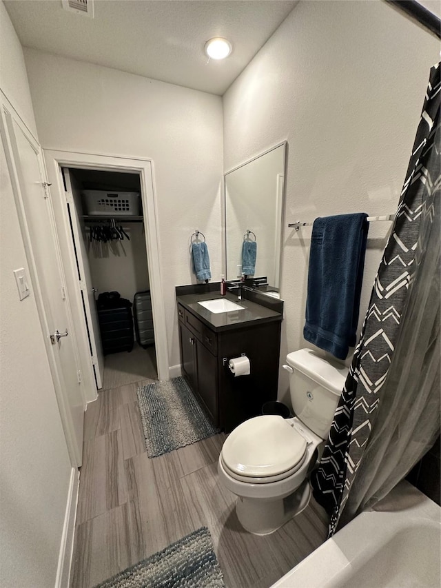 311 Eado Park Cir, Houston, TX 77020 - full bathroom featuring vanity, wood finished floors, curtained shower, and a walk in closet